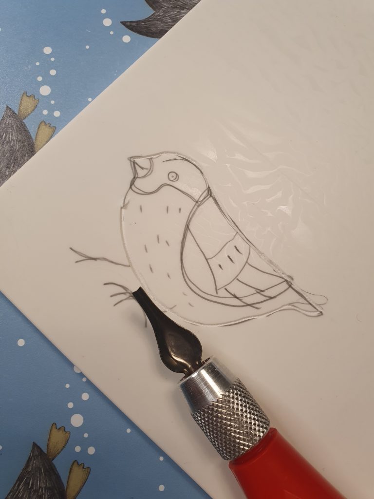 Lino med skjærekniv og påtegnet motiv.
