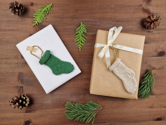 To gaver på et bord, begge har strikket julesokk som pynt.